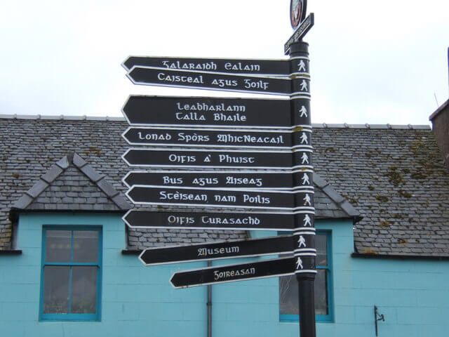 A signpost, written in Scottish Gaelic, showing pedestrian walking paths in the town of Stornoway, Scotland.