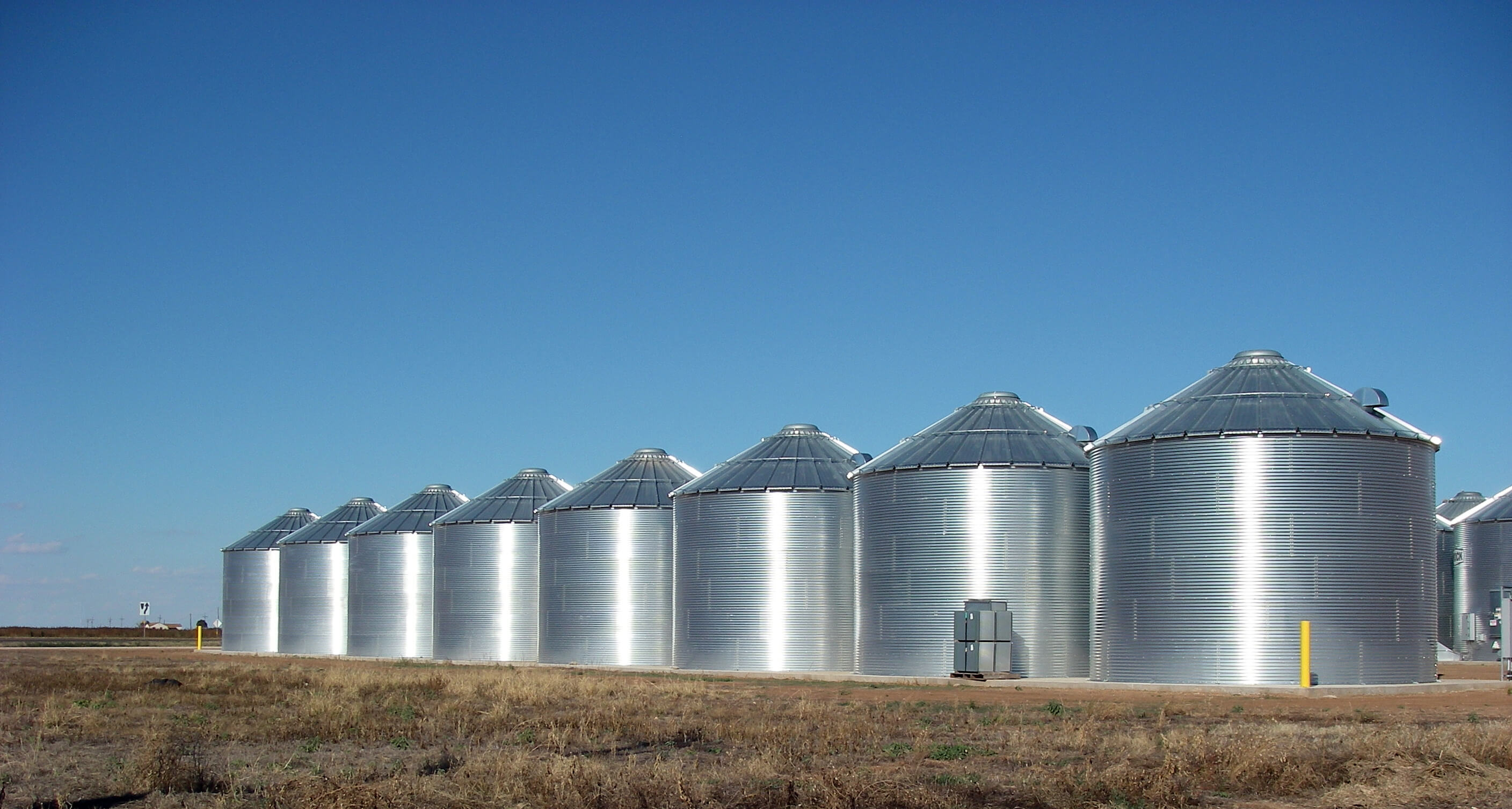 A set of metal grain silos on a farm in Texas