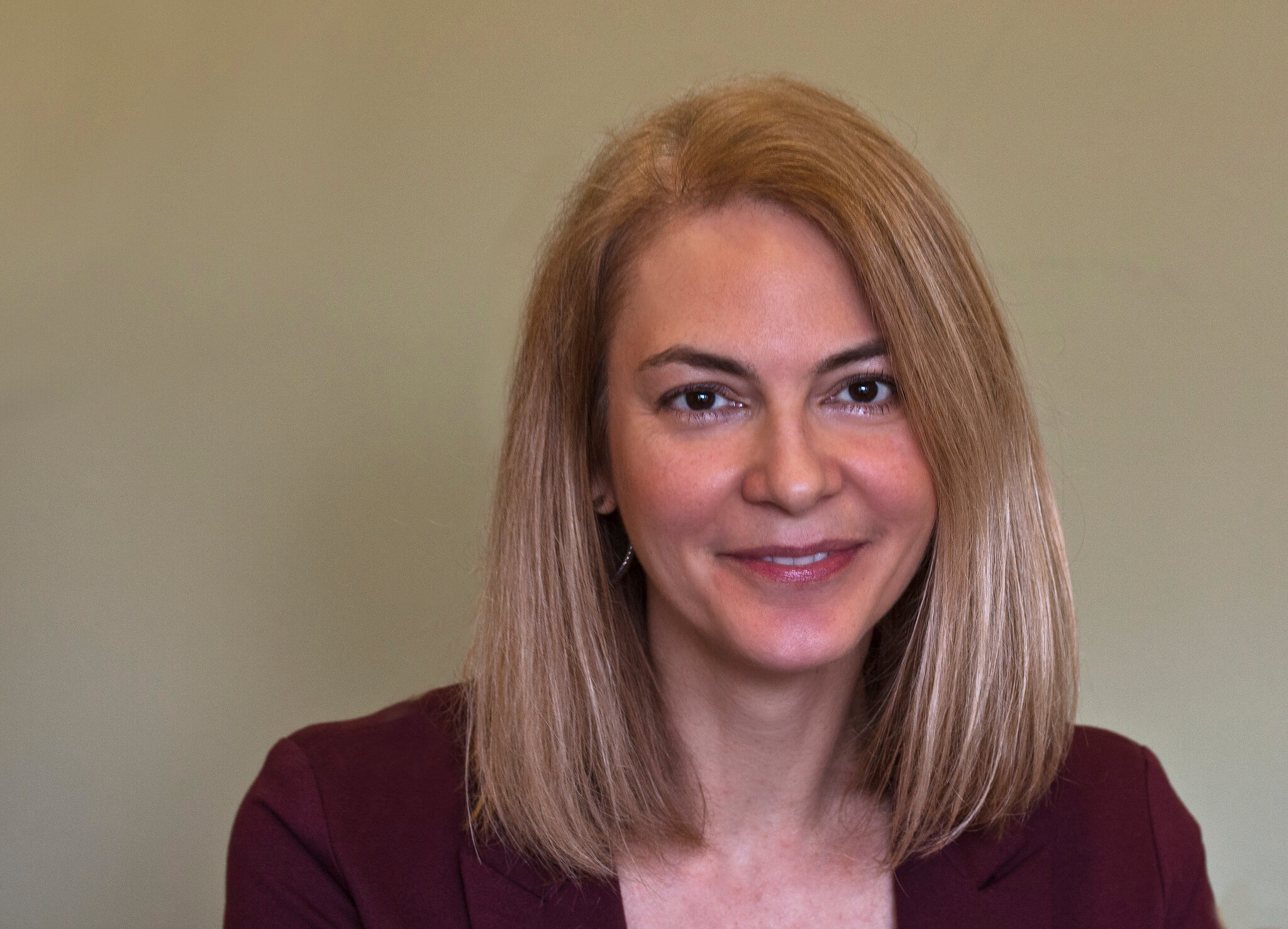 A headshot of Bianca, showing a middle-aged woman with brown eyes and blond hair.