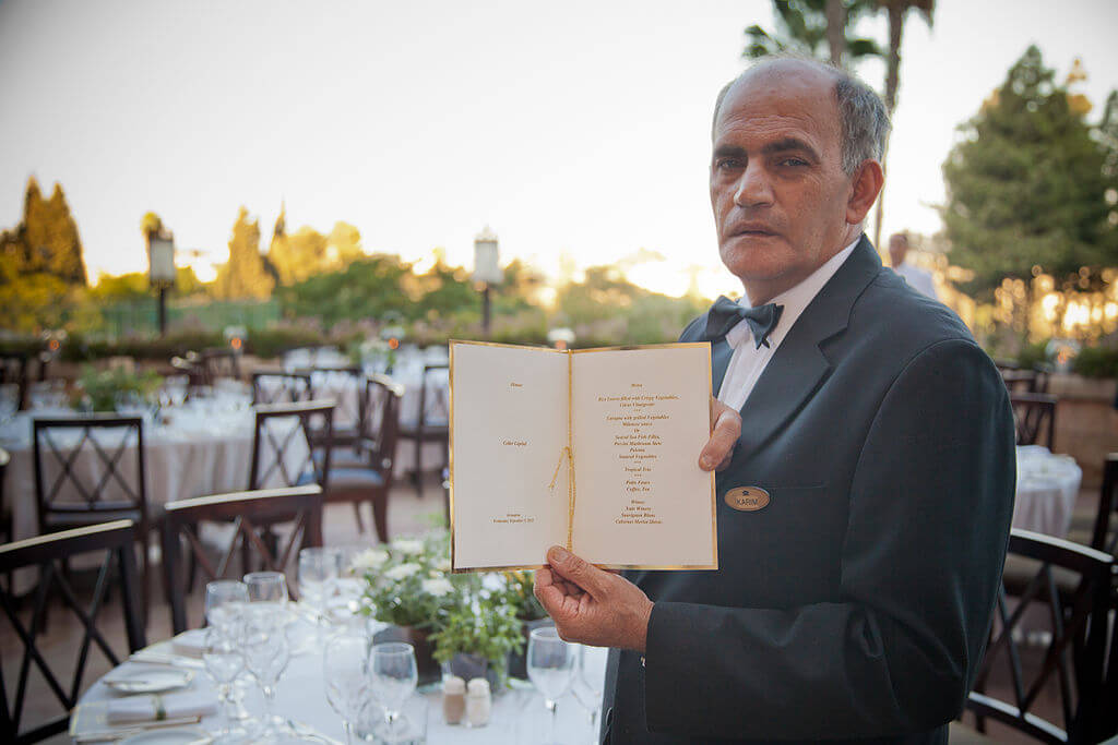 A waiter at a hotel restaurant shows the daily menu