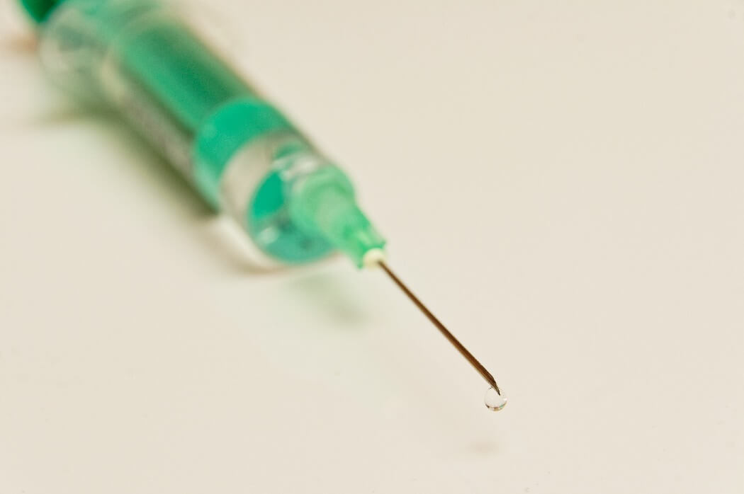 A disposable syringe, with a green liquid inside it